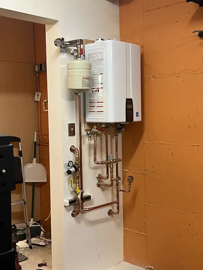 Plumbing technician inspecting water heater connections in Rapid Valley